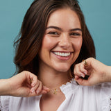 Woman wearing a gold necklace with a blue background